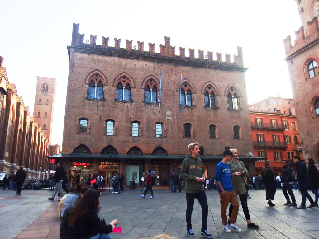 An image of tourists visiting the Palazzo Dei Notai in Bologna.
