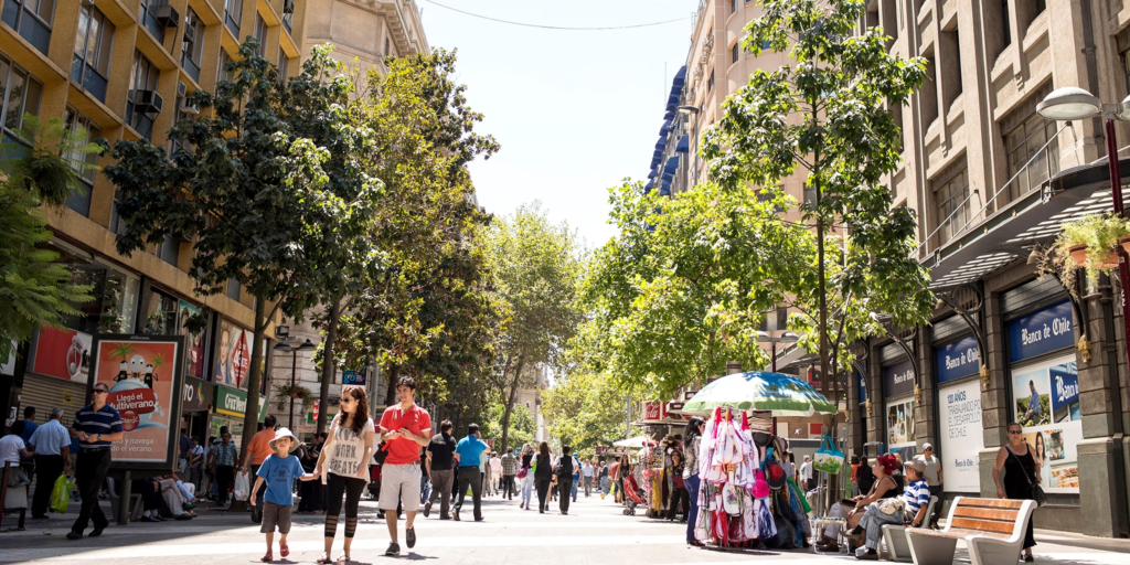 An image of tourists walking down Santiago's streets full of shop.