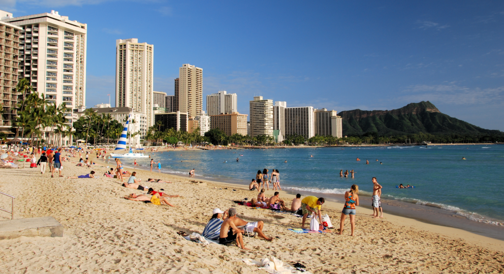 An image of tourists visiting Waikiki Beach, one of many destinations in senior travels to Hawaii.